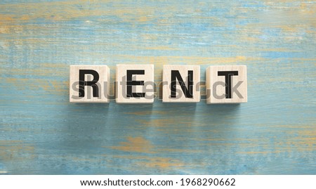 Concept word RENT on wooden cubes on a wooden background