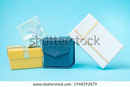 Beautiful small boxes with gifts on a turquoise background. Space for text.

