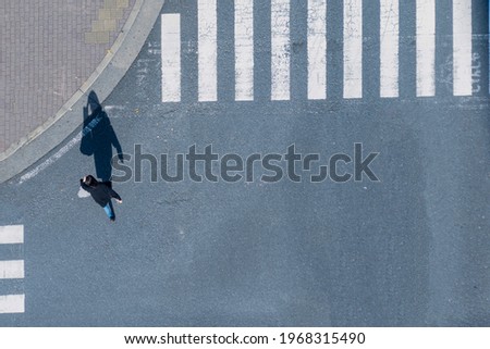 top aerial view of blur men and women people in winter cloth and business dress walk across crosswalk in street. Concept normal life of massive people with transportation and signage on the city road.