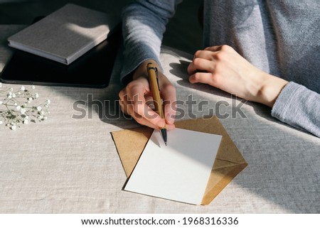 Woman writing romantic letter or  wedding invitation card Royalty-Free Stock Photo #1968316336