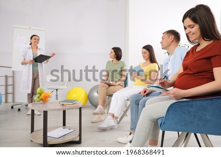 Pregnant women, man and doctor at courses for expectant parents indoors Royalty-Free Stock Photo #1968368491