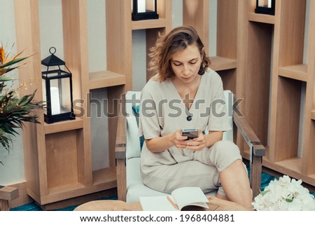 Beautiful woman texting and using smart phone for her business.
Girl taking notice in her schedule. Freelancer