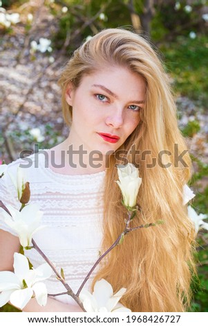 blond girl in blooming magnolias