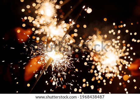 Burning fireworks and sparklers. Sparks and glare from fire flares. bengal lights Royalty-Free Stock Photo #1968438487