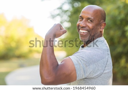 Healthy African American man flexing
and doing a bicep curl Royalty-Free Stock Photo #1968454960