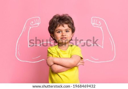 Strong little man child with bicep muscles picture. Concept for strength, confidence or defense from bullying. Kindergarten or school kid. Strong boy