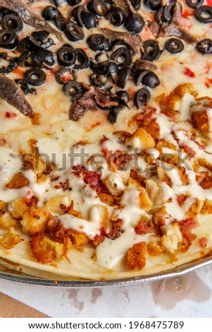 New York style pizza half anchovies and black olives and other half chicken bacon ranch toppings