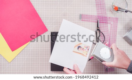 Flat lay. Little girl making a handmade Father's Day card from construction paper.