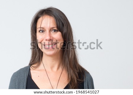 Headshot of a mediterranean woman aged 30-40 with a friendly big smile and white background