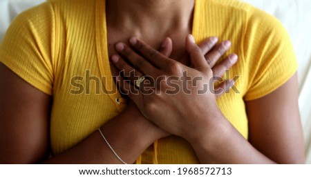 Young black woman putting hands on chest with faith and hope