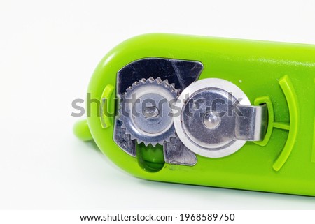 closeup shot of a green can opener isolated on white background