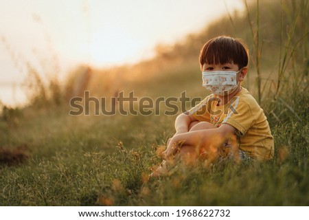 Asian children wearing a face mask outside during the Coronavirus COVID-19 virus pandemic