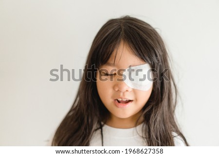 Lazy Eye amblyopia in children.Eye care.Little asian girl covered up with a special patch online learning at home.Occlusion therapy using an eye patch.Children care.child online learning education. Royalty-Free Stock Photo #1968627358