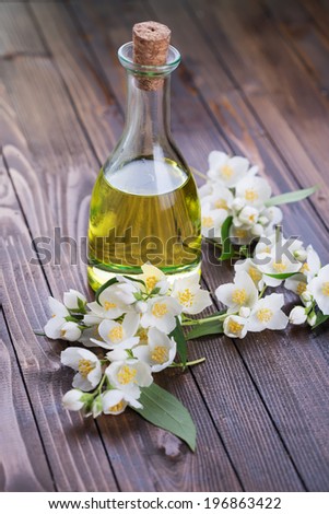 Essential aroma oil with jasmine  on wooden background. Selective focus.