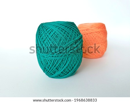 two skeins of green and orange soft crochet yarn for crafting