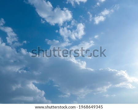 Beautiful white clouds against blue sky background. Nature photography. Elegant blue sky picture in sunlight. Big or tiny and soft white fluffy clouds in the blue sky. Wallpaper, texture background