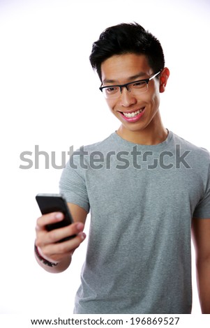 Happy asian man using smartphone on gray background