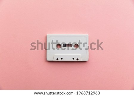 vintage white cassette tape on a pastel pink background