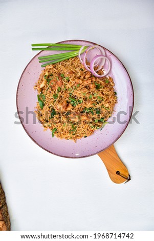 Seafood Noodles, Stir fry noodles with vegetables and shrimps in pink coluer dish. white background. Top view.