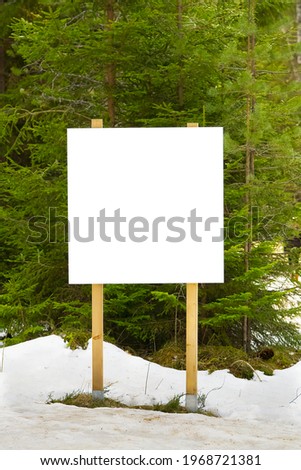 white advert billboard placeholder, blank information poster in forest. white empty Bulletin board in winter pine forest for outdoor info banner. mockup