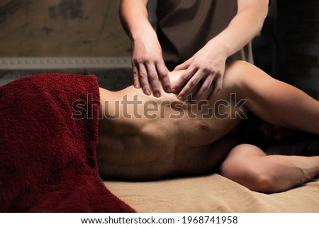 Sports massage. Breast massage. Physiotherapist doing a male breast massage to an athlete to a patient.