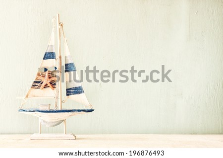 decorative boat over wooden textured background. filtered image.