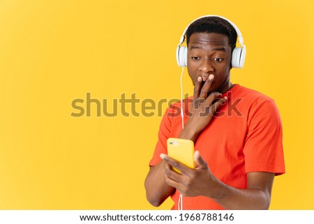 a man in headphones with a phone in his hands listening to music surprised look