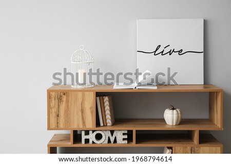 Shelf unit with picture near light wall in room