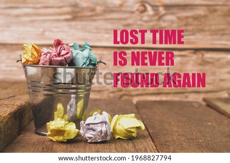 Bunch of paper waste on wooden board written with LOST TIME IS NEVER FOUND AGAIN