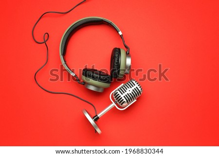 Headphones with microphone on color background Royalty-Free Stock Photo #1968830344