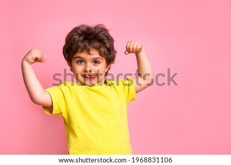 Portrait of little kid boy isolated over pink background showing tongue. Funny little power super hero kid showing muscles. Strength, confidence or defense from bullying. Kindergarten or school kid Royalty-Free Stock Photo #1968831106