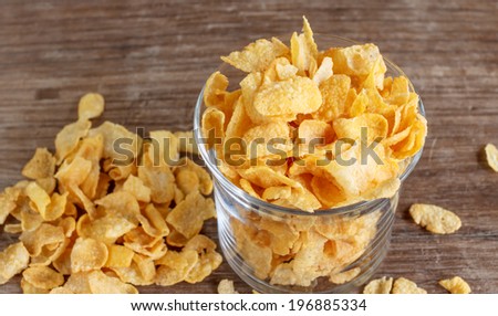 glass of cornflakes on wood