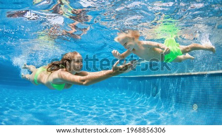 Happy people dive underwater with fun. Funny photo of mother, child in aqua park swimming pool. Family lifestyle, kids water sports activity, swimming lesson with parents on summer holiday Royalty-Free Stock Photo #1968856306