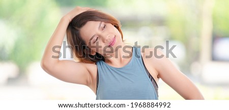 Young beautiful Asian woman in sports outfits doing stretching before workouts at hot during COVID-19 pandemic to keep a healthy life. Healthy young woman stretching and warming up to workouts