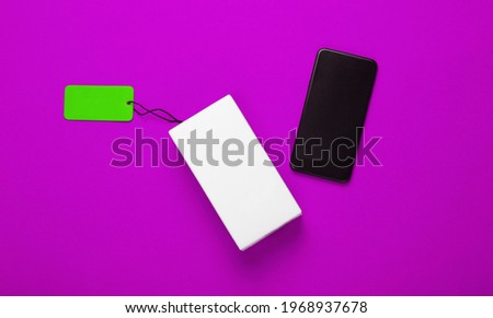 New smartphone and box with tag sale on pink background. Top view