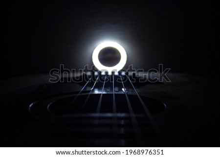 Guitar.Guitar chords with white light.Chords closeup.Music background.Guitar chords in the dark.Acoustic guitar closeup.Music in the dark Royalty-Free Stock Photo #1968976351