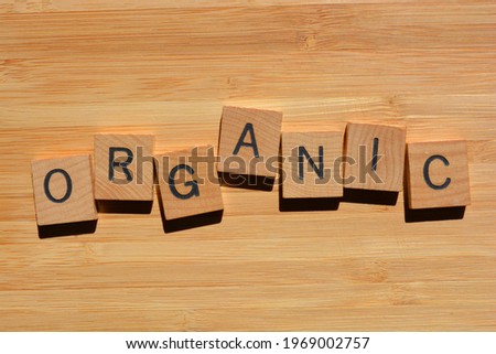 Organic, word in wooden alphabet letters isolated on bamboo wood background