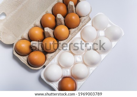 Brown and white eggs in cardboard boxes.