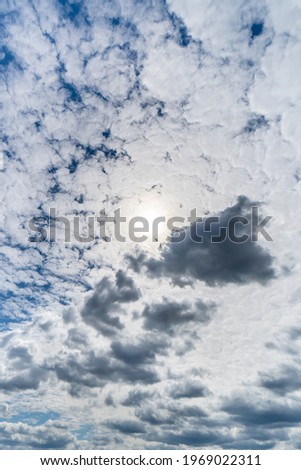 Cloudy sky with sun behind clouds.