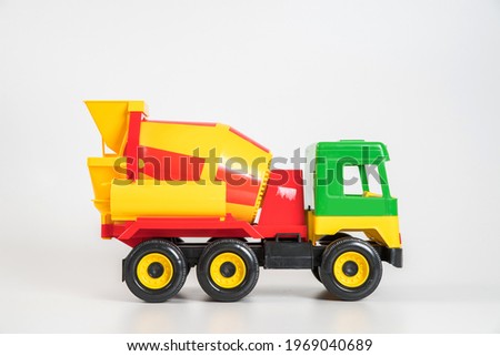 Multi-colored plastic children's toy cars on a white background. Concrete truck.