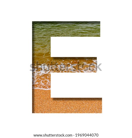 Sea shore font. The letter E cut out of paper on a background of the beach of seashore with coarse sand and emerald water. Set of decorative natural fonts.