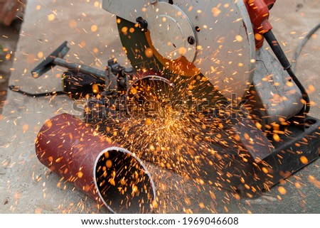 The iron was cutting pipes and orange sparks flashed out into li