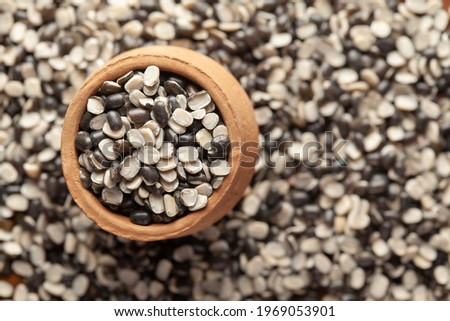 Macro Close up of Organic split black urad dal (Vigna mungo) with shell  in an earthen clay pot (kulhar) on the self background. Top view
