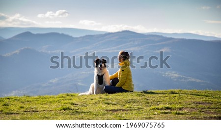woman with dog relaxing in green spring landscape