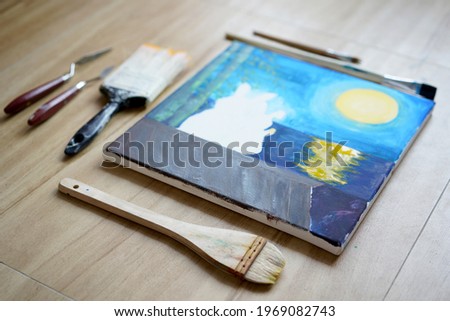 Acrylic art of two rabbit in love on roof under the moonlight at night, painting on drawing stand with brush. Blue wave on golden sand hand painting with brush technique. Art on canvas