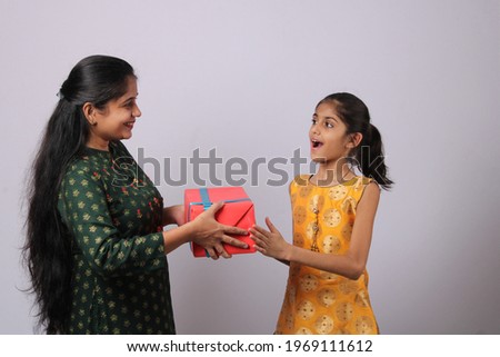 indian mother and daughter giving present