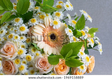 Soft and delicate flower arrangement on grey fabric background