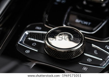 Gear shift controller in new luxurious car interior. Modern car multimedia system control joystick wheel.