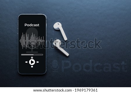 Podcast background. Mobile smartphone screen with podcast application, sound headphones. Audio voice with radio microphone on black. Recording studio or podcasting banner with copy space Royalty-Free Stock Photo #1969179361