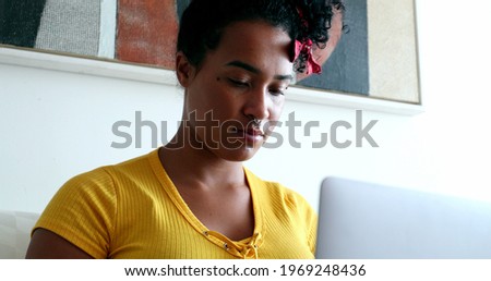 Young African American woman using laptop computer working from home